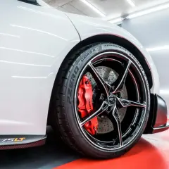 Biały McLaren 675LT z błyszczącymi felgami aluminiowymi i czerwonymi zaciskami hamulcowymi. Zabezpieczenie felg aluminiowych zapewnia im lśniący wygląd.