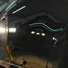 Widoczne są zarysowania i hologramy na czarnym lakierze, czekające na renowację lakieru samochodowego.