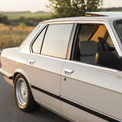 Jasny sedan na tle zachodzącego słońca, gotowy do wymiany uszczelek w samochodzie.