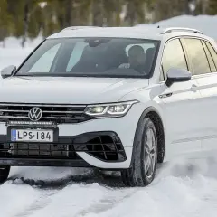 Biały Volkswagen Tiguan na śniegu podczas auto bild test opon całorocznych.
