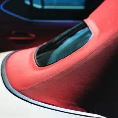 Czerwony dach cabrio z czarną ramką okna.
