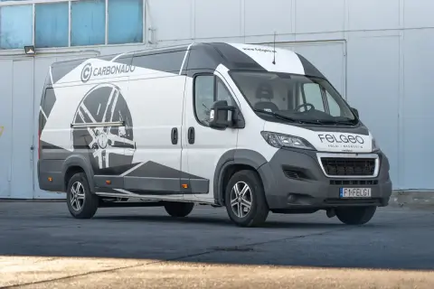 Biały van z grafiką felgi na boku. Idealny dobór felg do auta to klucz do stylu i bezpieczeństwa.