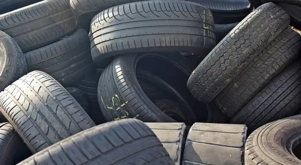 Stos starych opon samochodowych. Zastanawiasz się, gdzie wyrzucić opony? Recykling to najlepsze rozwiązanie.
