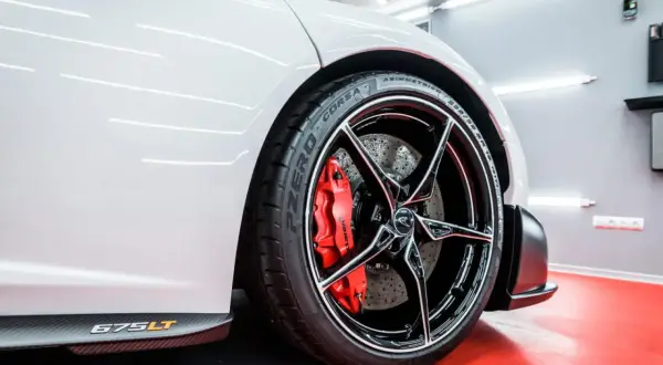 Biały McLaren 675LT z błyszczącymi felgami aluminiowymi i czerwonymi zaciskami hamulcowymi. Zabezpieczenie felg aluminiowych zapewnia im lśniący wygląd.