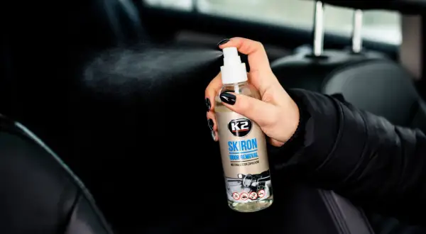 Dłoń rozpyla preparat K2 SKIRON ODOR REMOVAL, który skutecznie pomoże Ci dowiedzieć się, czym zneutralizować zapach psa w samochodzie.