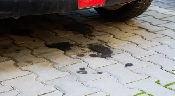Plamy oleju silnikowego na kostce brukowej. Dowiedz się, jak usunąć stare plamy z oleju silnikowego, aby przywrócić czystość podjazdu.
