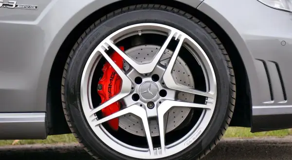 Błyszczące felgi aluminiowe AMG z czerwonymi zaciskami hamulcowymi. Wyobraź sobie czyszczenie felg aluminiowych sodą oczyszczoną, by przywrócić im dawny blask.