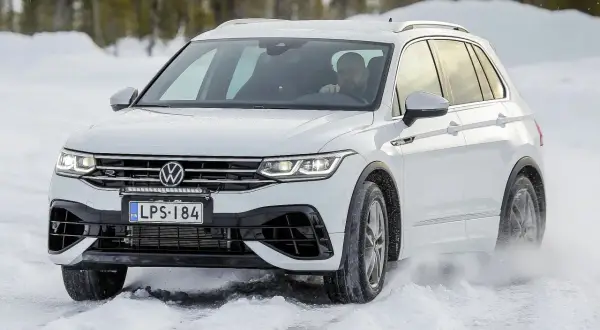 Biały Volkswagen Tiguan na śniegu podczas auto bild test opon całorocznych.