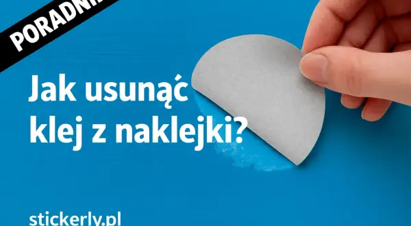 Poradnik: Jak usunąć klej z naklejki? Dłoń trzyma fragment szarej naklejki, odsłaniając niebieskie tło.
