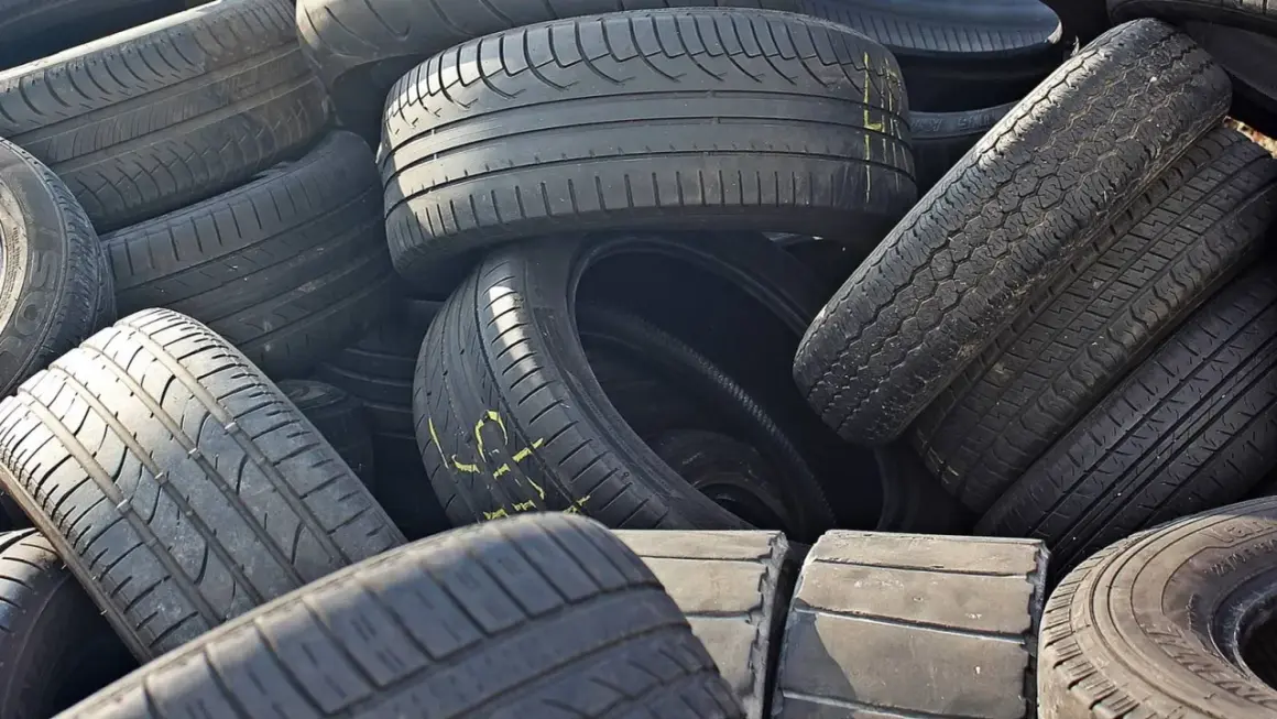 Stos starych opon samochodowych. Zastanawiasz się, gdzie wyrzucić opony? Recykling to najlepsze rozwiązanie.