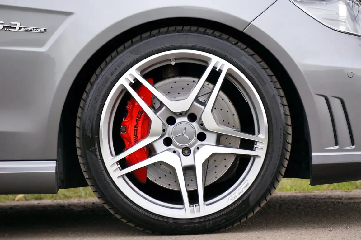 Błyszczące felgi aluminiowe AMG z czerwonymi zaciskami hamulcowymi. Wyobraź sobie czyszczenie felg aluminiowych sodą oczyszczoną, by przywrócić im dawny blask.