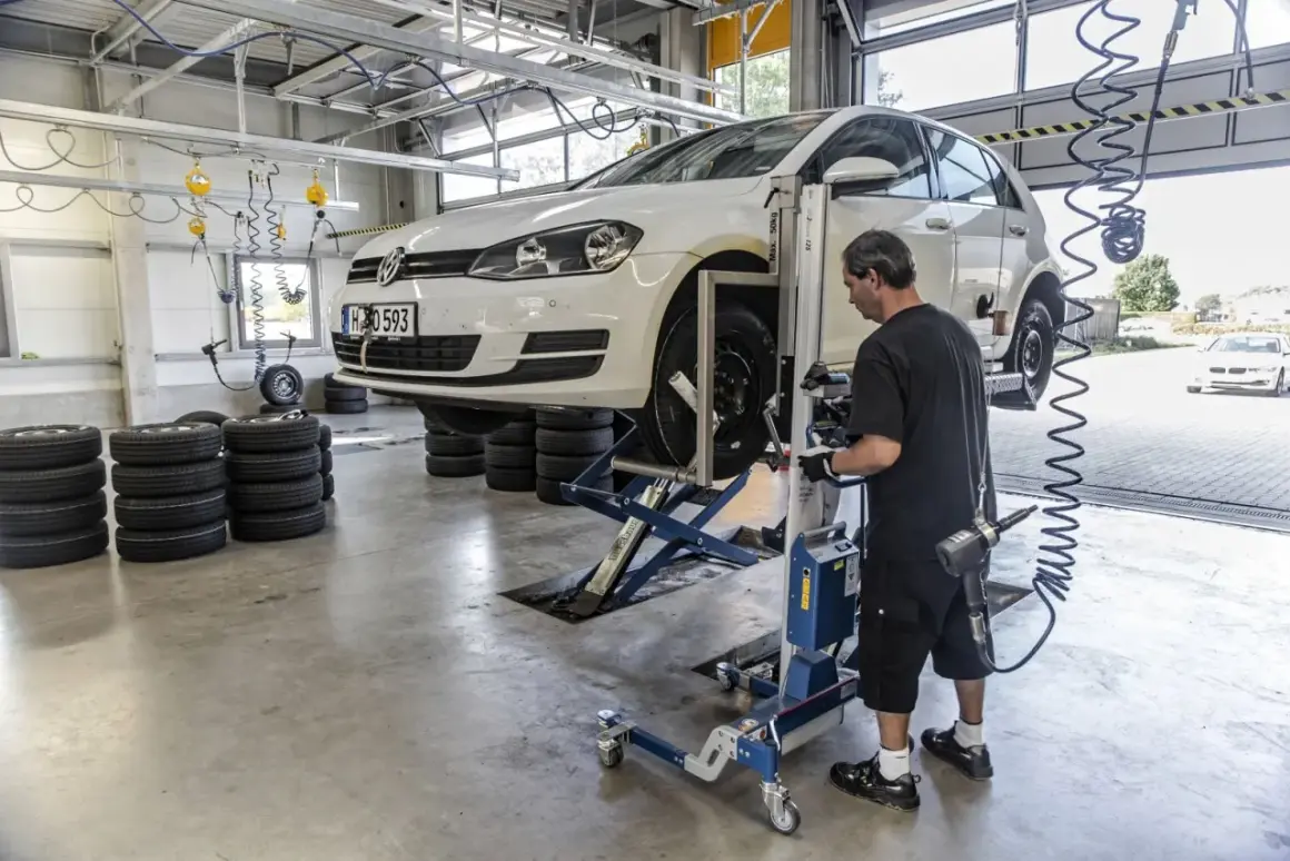 Mechanik sprawdza opony samochodu na podnośniku, przygotowując go do homologacji opon.