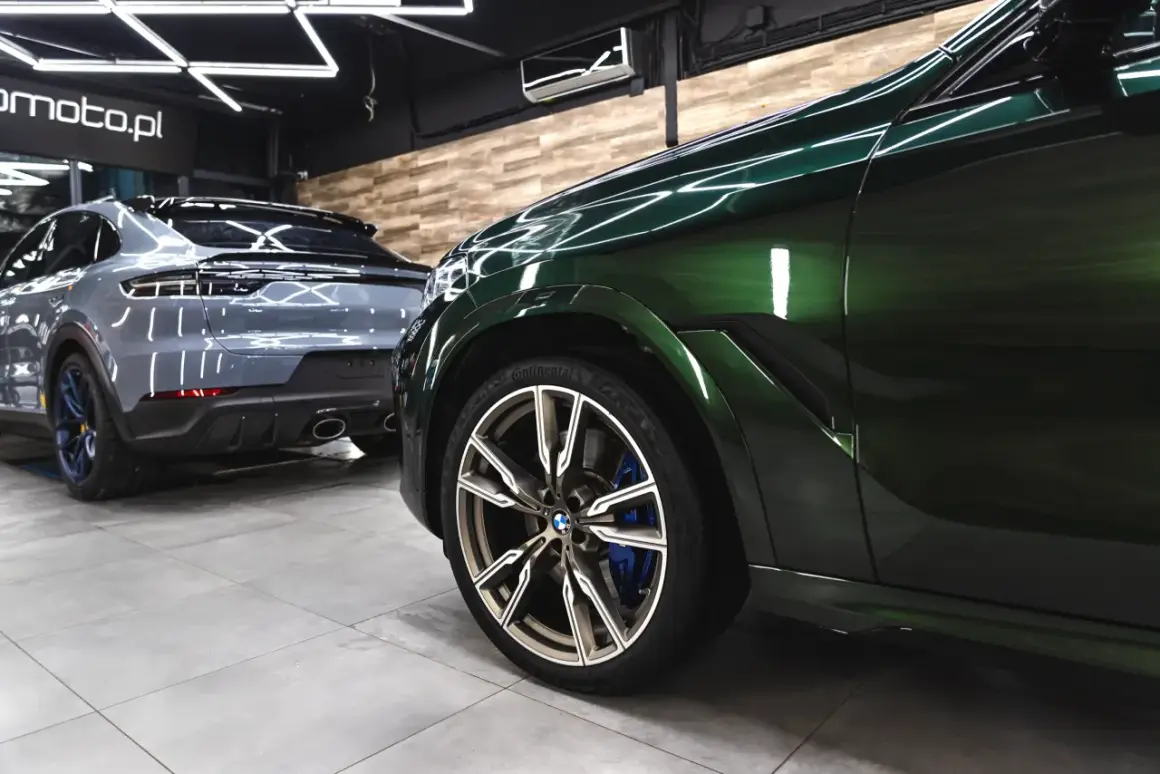 Błyszczące, zielone BMW i szary Porsche w profesjonalnym studiu auto detailing.