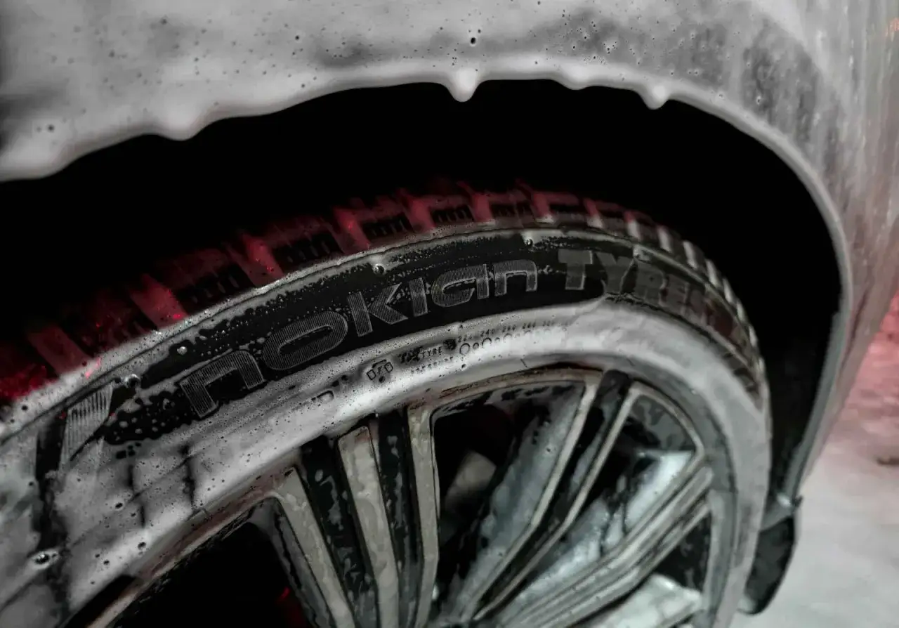 Błyszcząca opona Nokian Tyres Seasonproof 2 pokryta pianą podczas mycia.