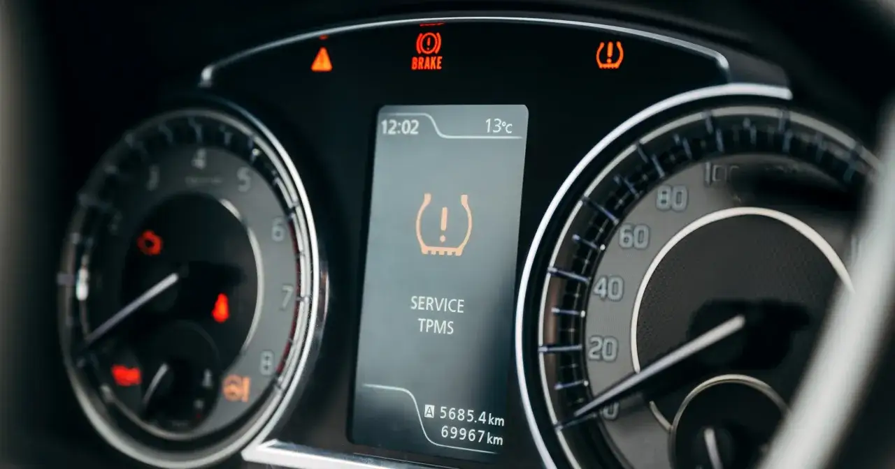 Kontrolka TPMS świeci, sugerując problem z ciśnieniem w oponach. Czy można wyłączyć czujniki ciśnienia w oponach? Na desce rozdzielczej widać też kontrolkę hamulca.