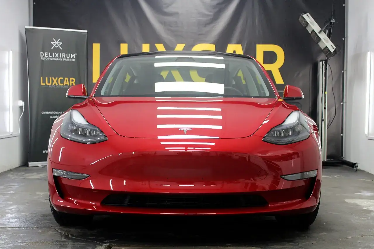 Czerwona Tesla lśni w studio detailingowym.