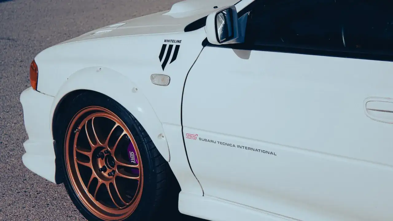 Miedziane felgi świetnie komponują się z białym autem, podkreślając sportowy charakter Subaru WRX STI.