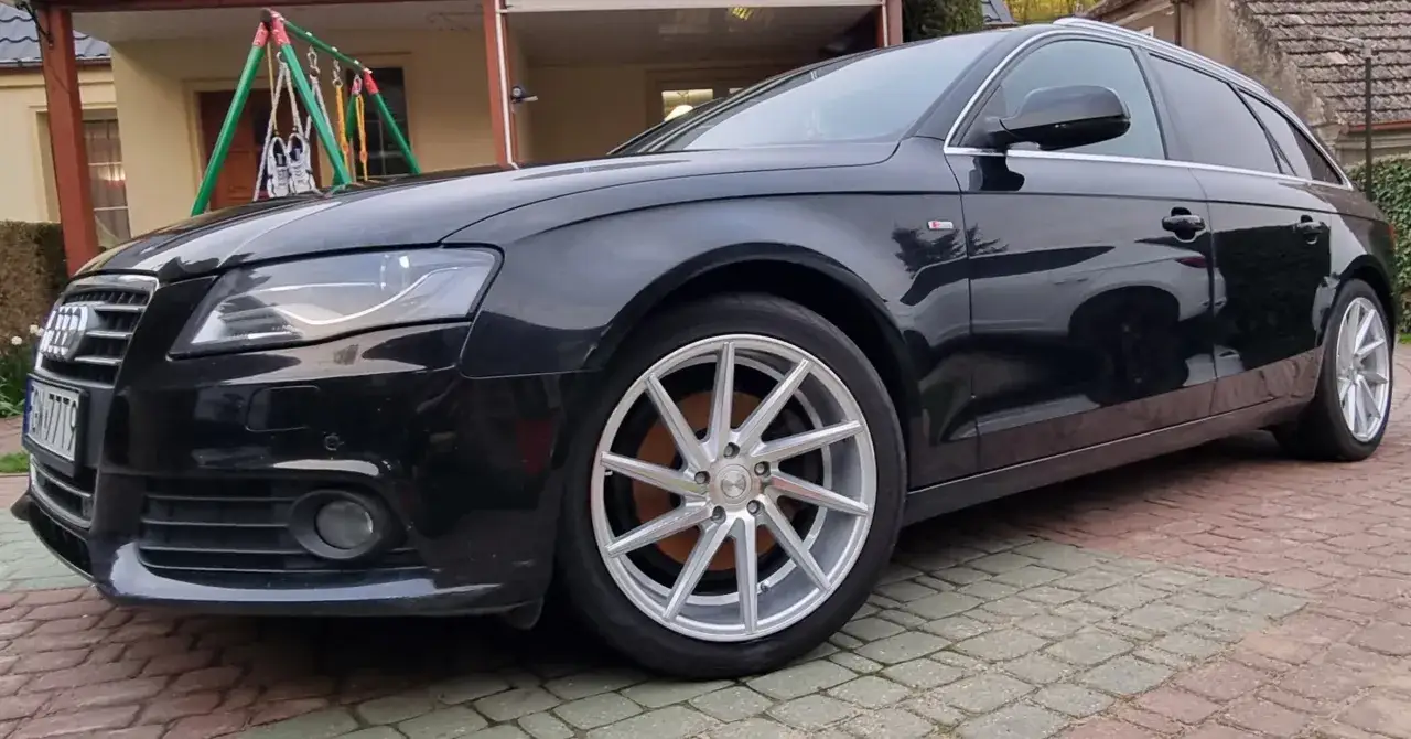 Czarny Audi z błyszczącymi, srebrnymi felgami aluminiowymi, które dodają mu sportowego charakteru.