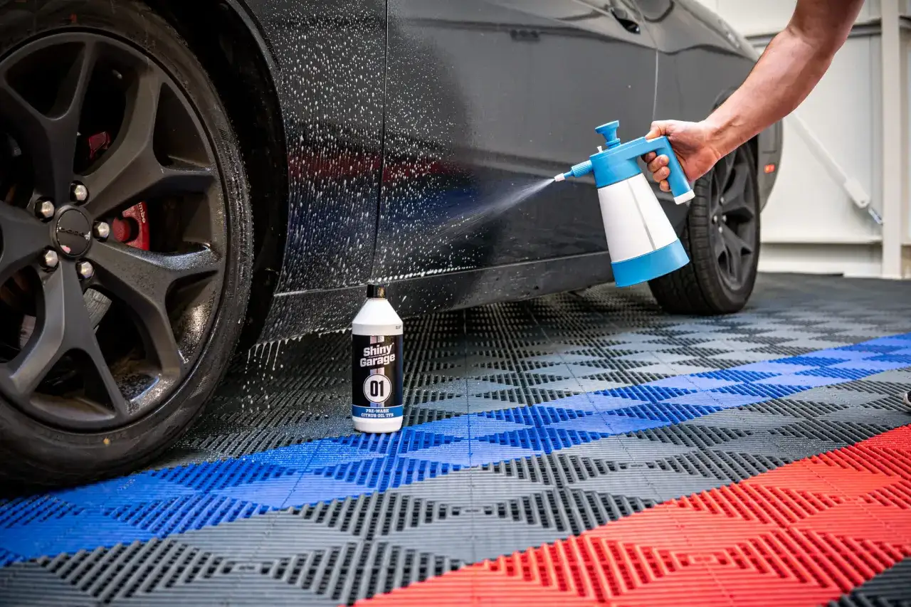 Oprysk pre-wash Shiny Garage na czarnym aucie. Pianownica rozpyla produkt, przygotowując samochód do mycia.