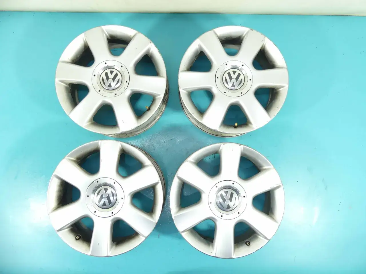 Cztery aluminiowe felgi Volkswagen z logo VW, idealne do Golfa 5. Rozstaw śrub golf 5 jest standardowy dla tego modelu.