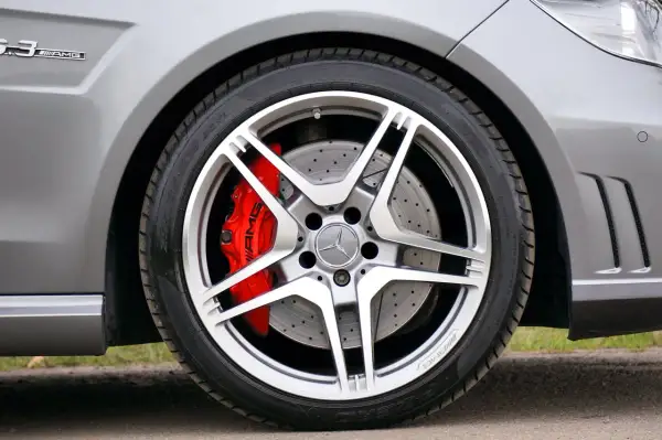 Błyszczące felgi aluminiowe AMG z czerwonymi zaciskami hamulcowymi. Wyobraź sobie czyszczenie felg aluminiowych sodą oczyszczoną, by przywrócić im dawny blask.