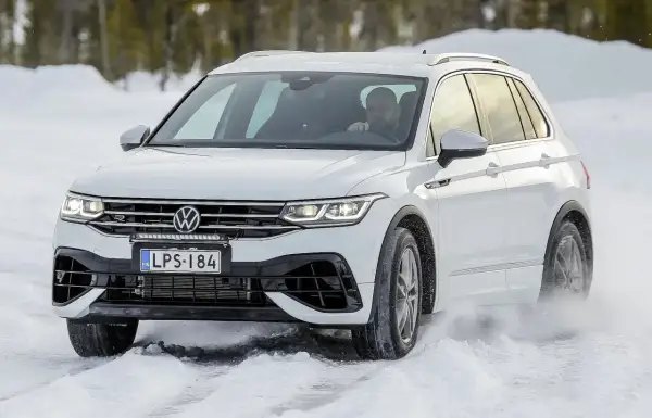 Biały Volkswagen Tiguan na śniegu podczas auto bild test opon całorocznych.