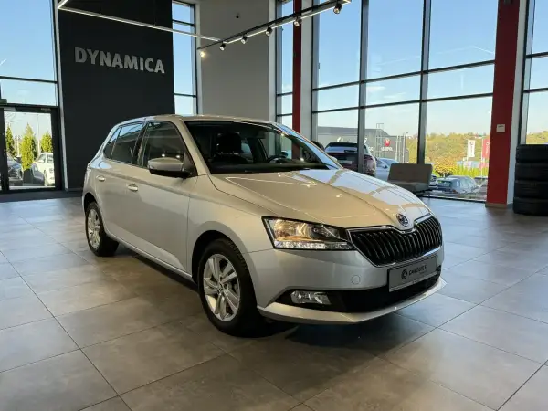 Srebrna Skoda Fabia 1 z nowymi oponami stoi w salonie samochodowym.